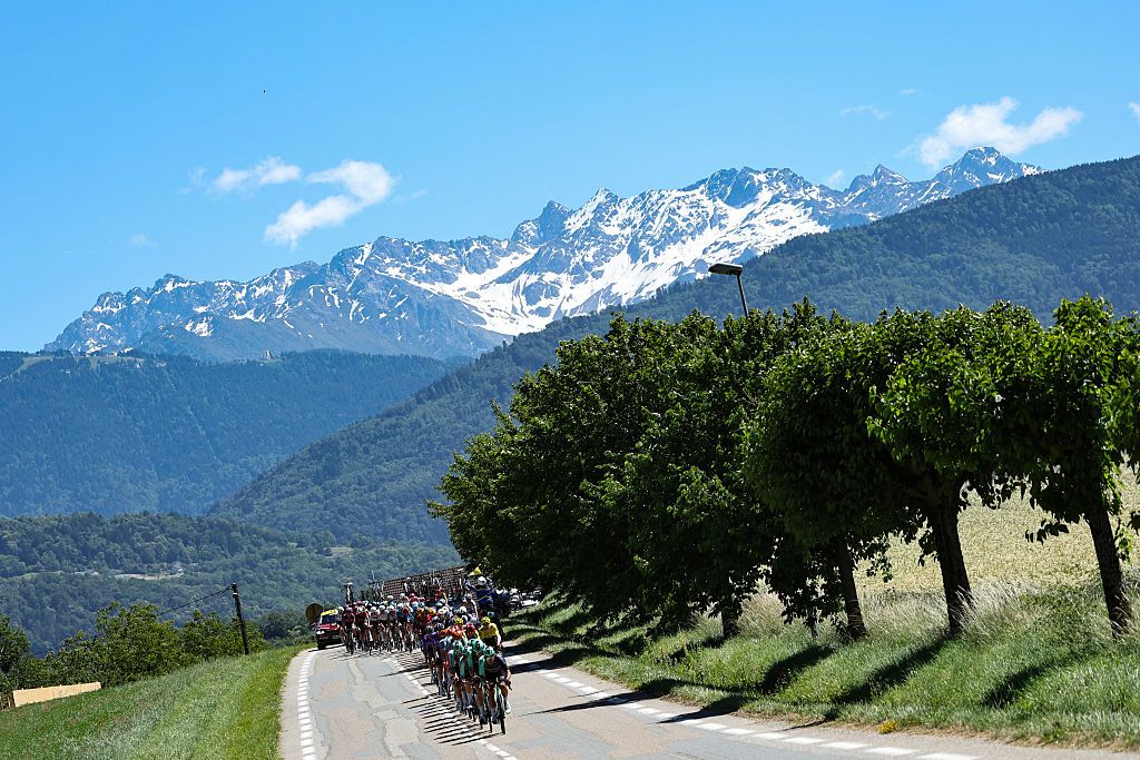 The pack of riders (peloton) cycles during the 6th stage of the Tour Auvergne-Rhone-Alpes cycling race (formerly known as the Criterium du Dauphine), 182,3km between Saint-Vulbas and Crest-Voland in the French Alps on June 12, 2026. (Photo by Anne-Christine POUJOULAT / AFP)